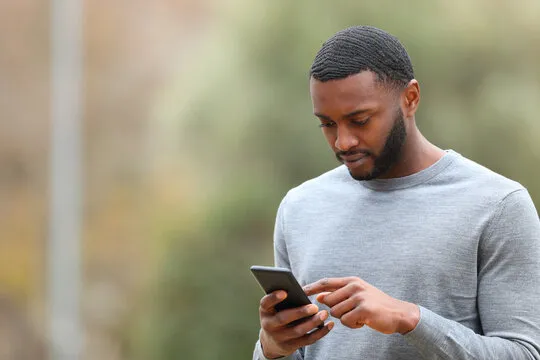A person looking at his phone and reviewing S9 Game